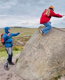 Two students climbing rocks at Higger Torr