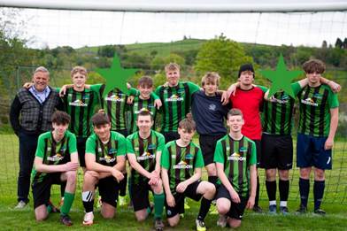 Key Stage 4 Boys Football Team smiling together on the pitch