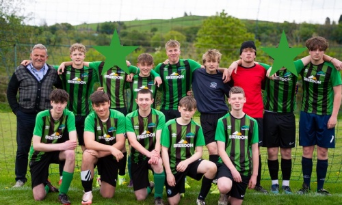 Key Stage 4 Boys Football Team smiling together on the pitch